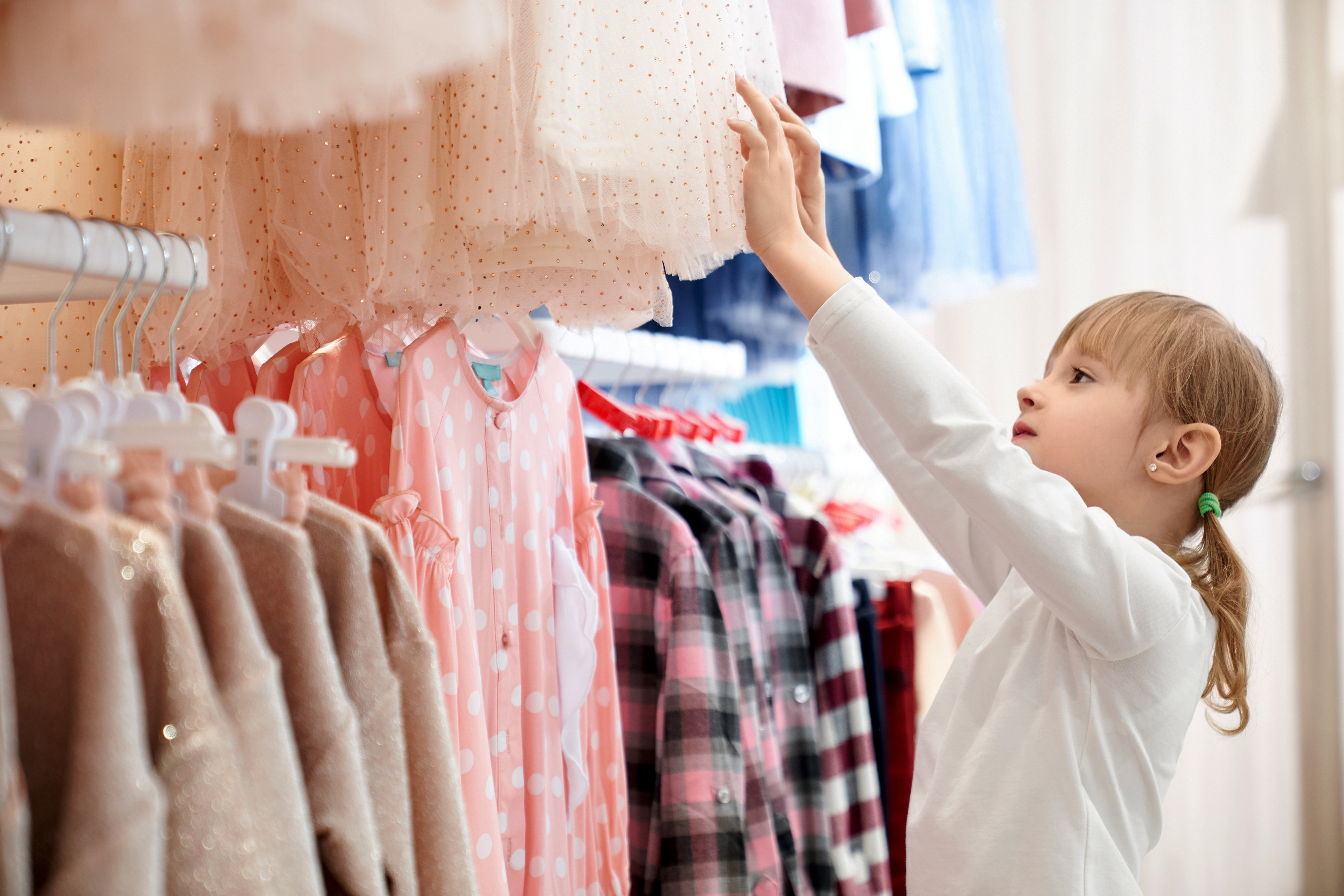 Little girl picking clothes at a store